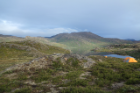 The team’s bright orange tents dot the shore of a lake, set against the wild beauty of a remote region of Greenland. Credit: Anna McKee