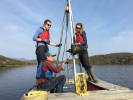UB researchers including Assistant Professor of Geology Elizabeth Thomas (sitting); geology master’s student Meg Cocoran (left, standing); and geology PhD student Allison Cluett (right, standing).