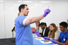 Robert Benjamin, a second-year med student, gives the students some directives on handling the materials.