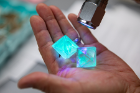 Science teacher Jeff Yap demonstrates glowing crystals his class created using highlighter ink for a past edition of the U.S. Crystal Growing Competition.