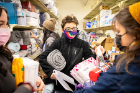 Students gather blankets and bedding as they put together welcome kits for refugees.